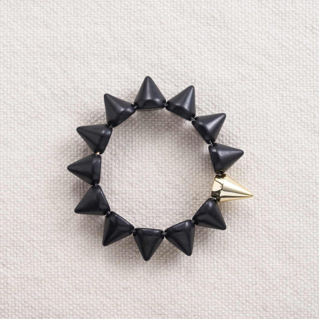 A calming stone, Howlite calms communication, facilitates awareness and encourages emotional expression.  In spike form, these make for a great edgy addition to any outfit.   Each bracelet has one accent gold spike  Available in black, white, red, pink, yellow, orange, turquoise, blue and purple