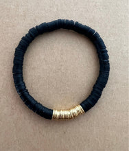 Load image into Gallery viewer, A very versatile black stack featuring a black ashanti glass bracelet with with grey recycled glass beads, and black polymer clay bracelet and a onyx bracelet with brushed gold accents  All bracelets measure 7 inches but can be customized upon request 

