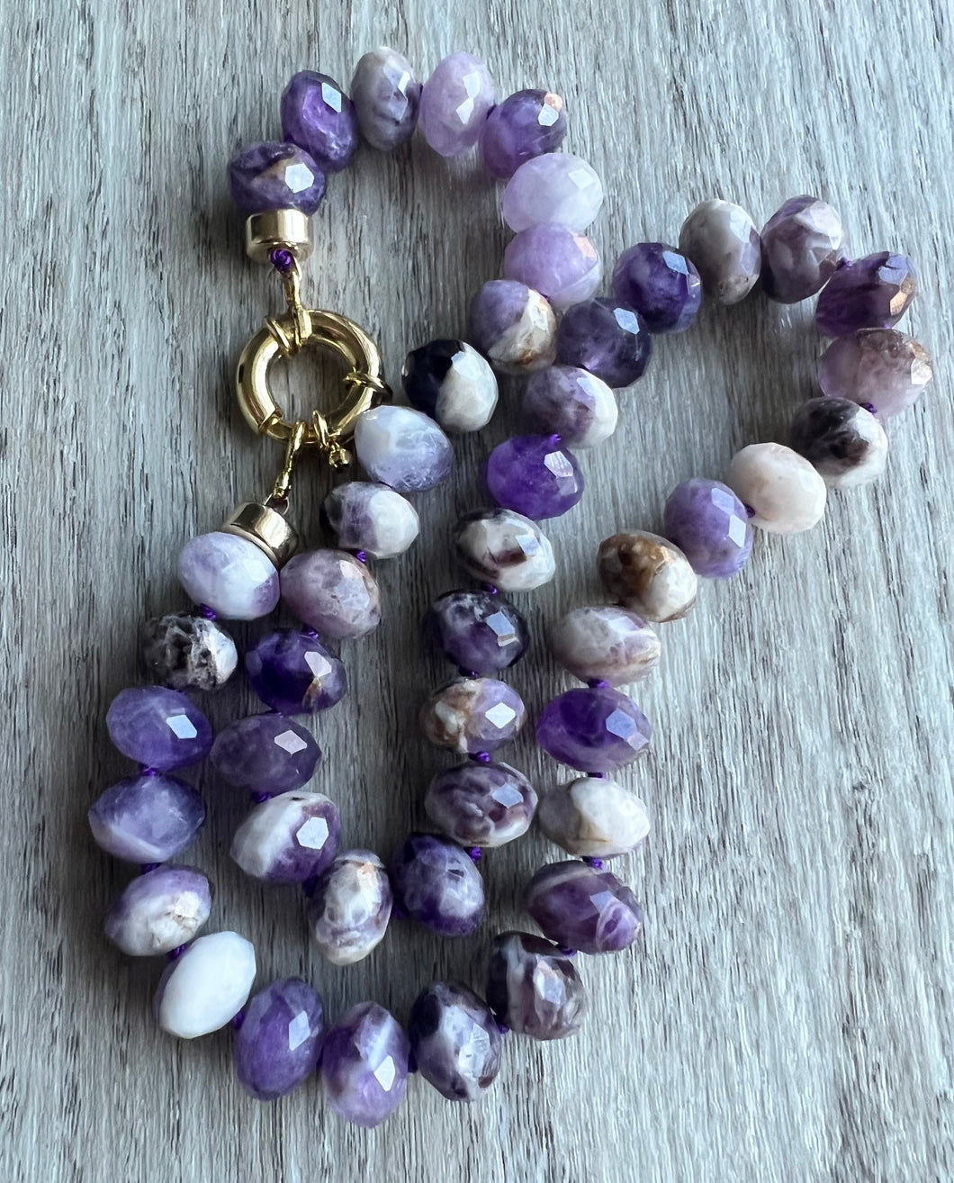 For the amethyst lover, these gorgeous 10mm faceted beauties are unforgettable.  Hand knotted on purple thread, this necklace measure 19 inches   Finished off with gold filled end caps and a gold filled sailor's clasp