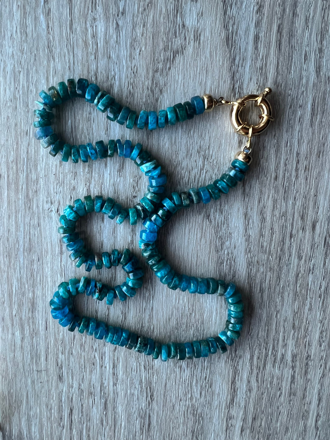 Hand knotted on blue silk, these pretty blue apatite heishi beads come together to create a stunning 19 inch necklace that's perfect on it's own or in your favorite necklace stack Finished off with gold filled end caps and a gold filled sailor's clasp