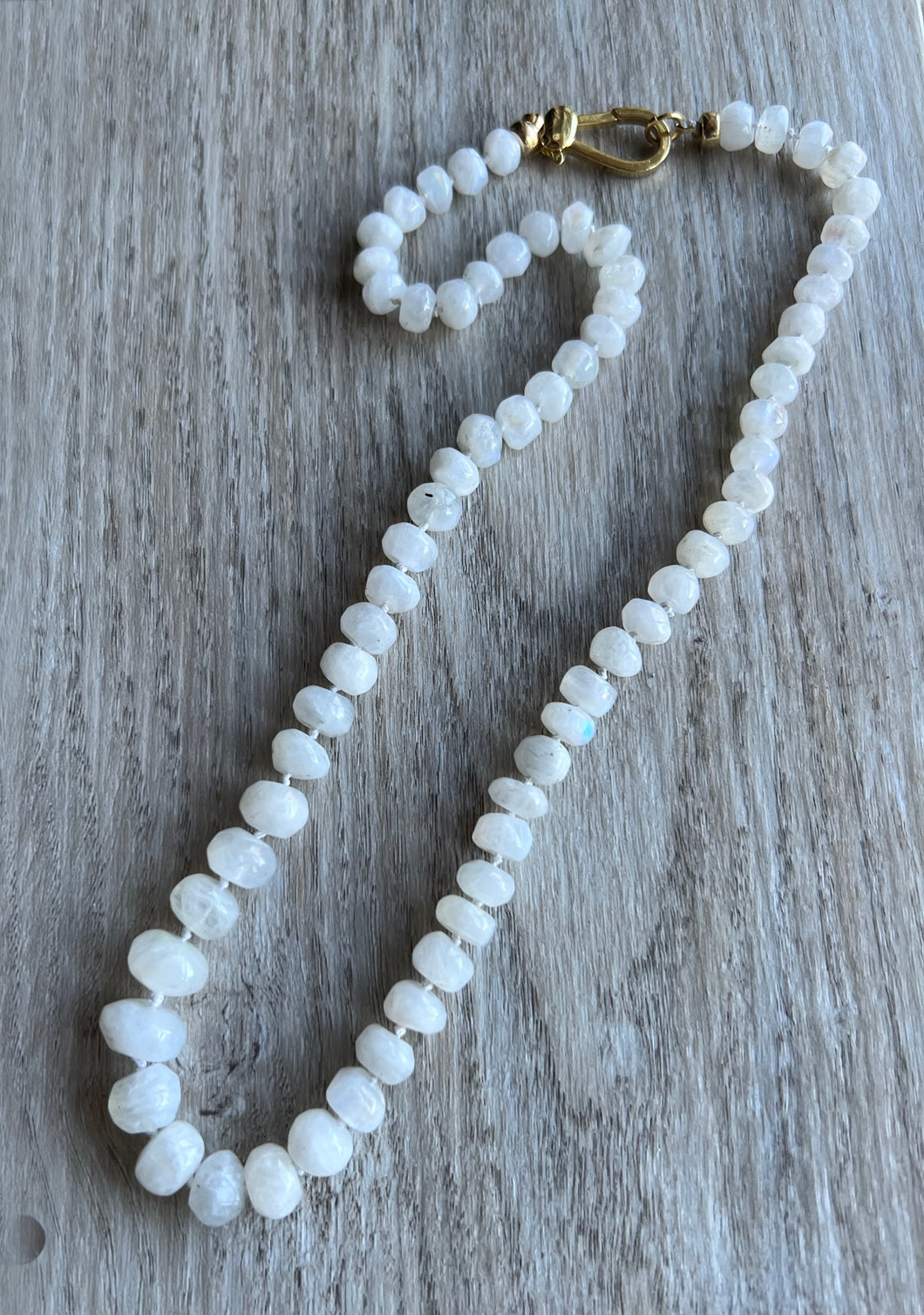 Beautiful smooth graduated moonstones that feature 6mm to 10mm rondelles.  Hand knotted on white silk, this necklace measures 22 inches    Finished off with gold filled end caps and a gold filled lobster clasp