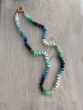 Load image into Gallery viewer, Hand knotted on white silk thread this multi color necklace features 8mm stones including moonstone, turquoise, aventurine, opals, lapis lazuli, and emerald. This necklace measures 21 inches and is finished off by a gold filled sailor clasp
