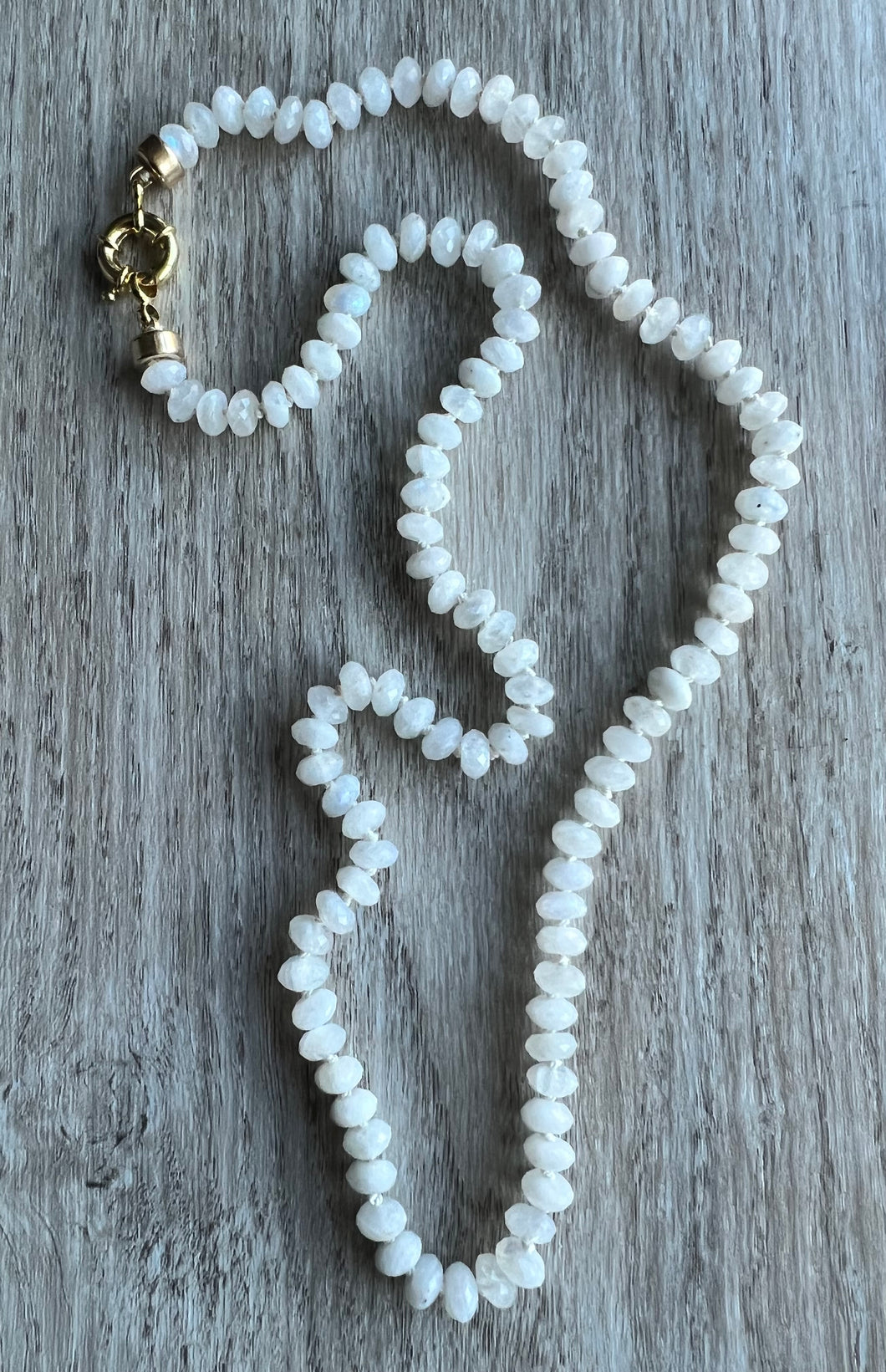 Hand knotted on white silk thread, this necklace features sparkling 6mm faceted moonstones and measures 22 inches  Finished off with gold filled end caps and a gold filled sailor's clasp