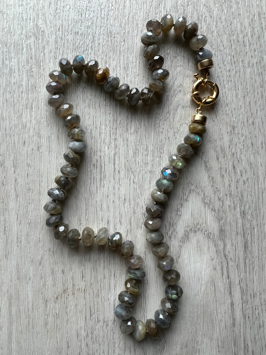 9mm faceted Labradorite gemstones hand knotted on grey silk thread.  A stone of transformation, Labradorite is a useful companion through change, imparting strength and perseverance.  This necklace with gorgeous AAA quality labradorite is finished off with a gold filled clasp and measures 18 inches